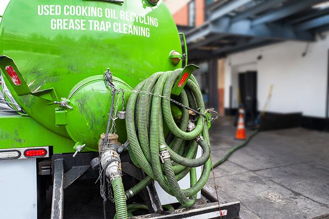 a grease trap being pumped by a sanitation technician in Cumberland RI